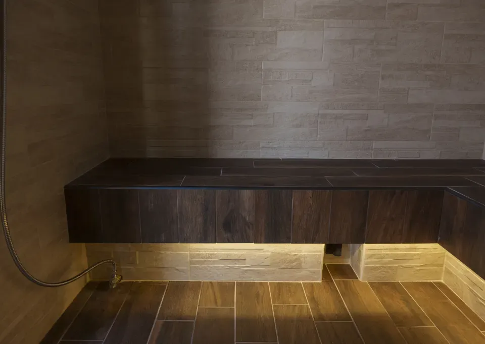 Interno del bagno di vapore, con panca in legno scuro e illuminazione soffusa