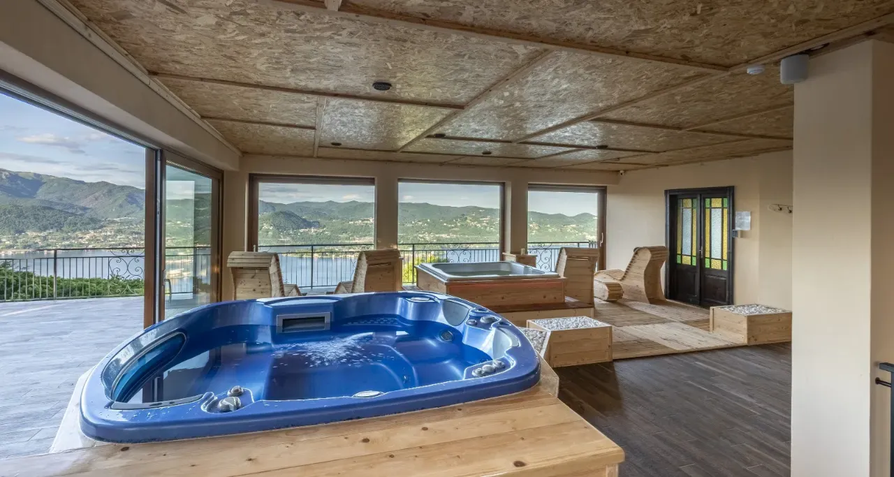 La zona idromassaggio della Kairos SPA, con vasche, lettini in legno e vetrate panoramiche sul Lago d'Orta