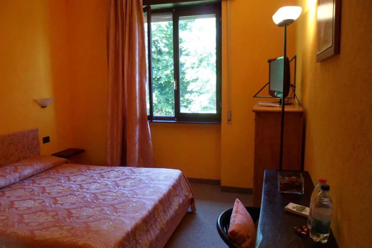 Camera Doppia Standard con letto matrimoniale e finestra affacciata sul verde del giardino