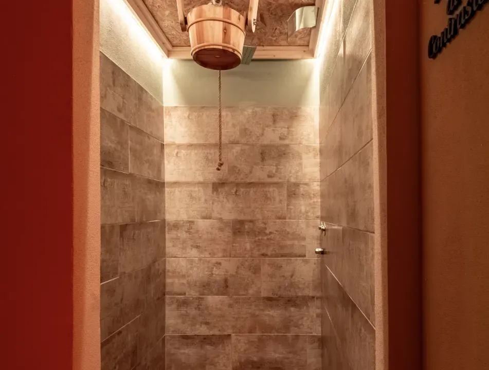 La doccia di contrasto: secchio in legno ribaltabile a soffitto, con corda per l'acqua fredda