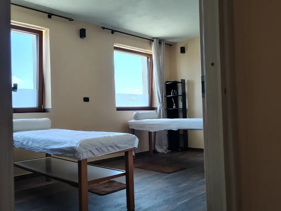 Cabina massaggi della Kairos SPA con due lettini preparati e finestre affacciate sull'esterno