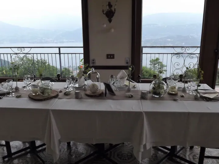 Tavolo del ristorante apparecchiato davanti alle vetrate affacciate sul Lago d'Orta