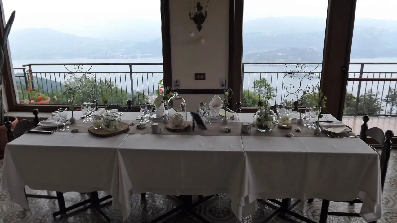 Tavolo del ristorante apparecchiato davanti alle vetrate affacciate sul Lago d'Orta