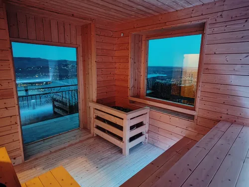 Sauna finlandese in legno della Kairos SPA, con stufa e ampie vetrate affacciate sul Lago d'Orta